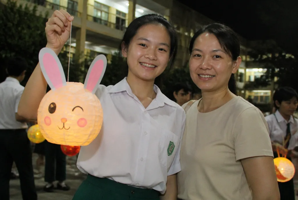 Ng Hui Wen and her mother with the rabbit lantern she built in art class.