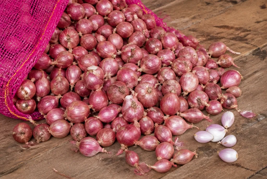Shallots spilling from a pink mesh sack