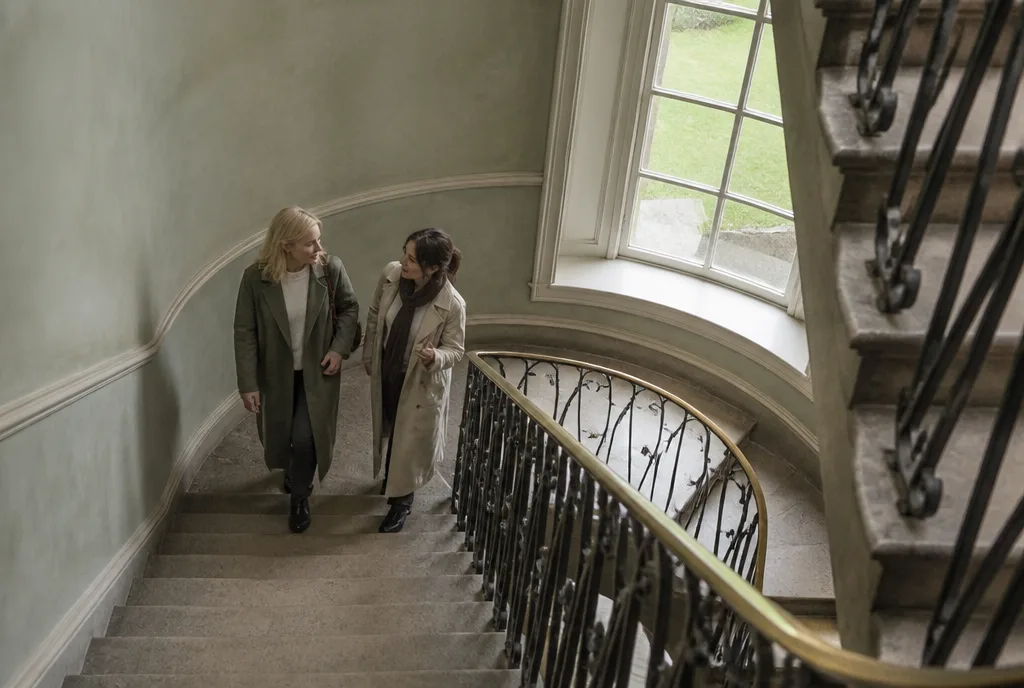 Two women talking as they come down the townhouse stair