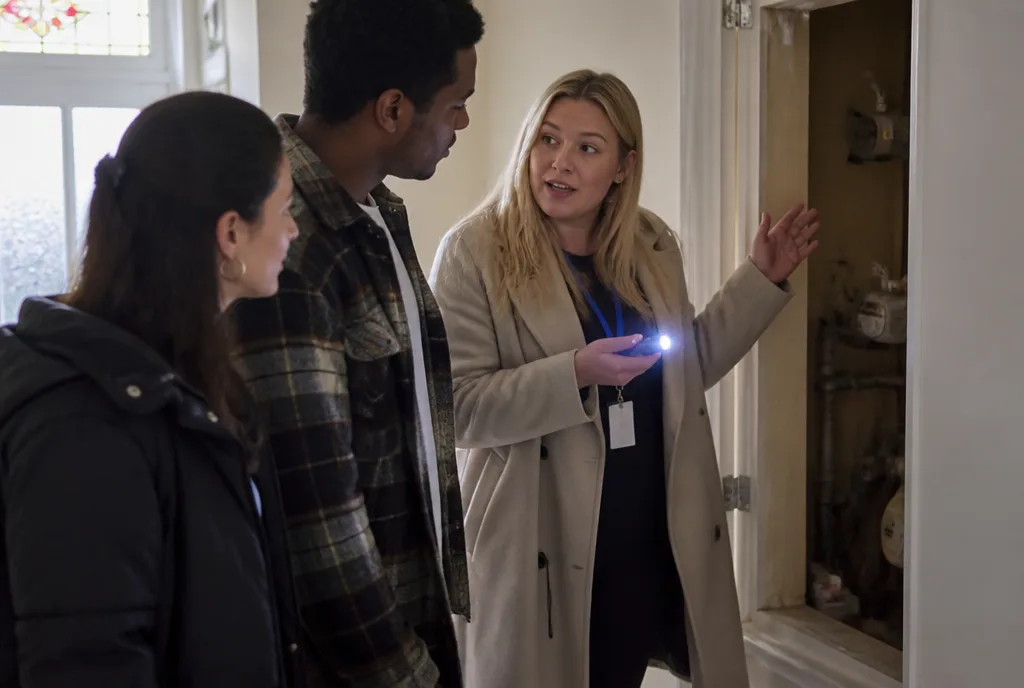 Property manager showing tenants the meter cupboard at check-in