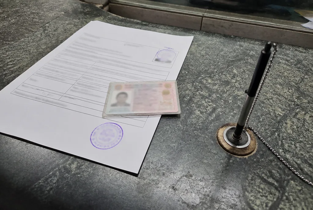 A stamped application form and identity document on a land office counter