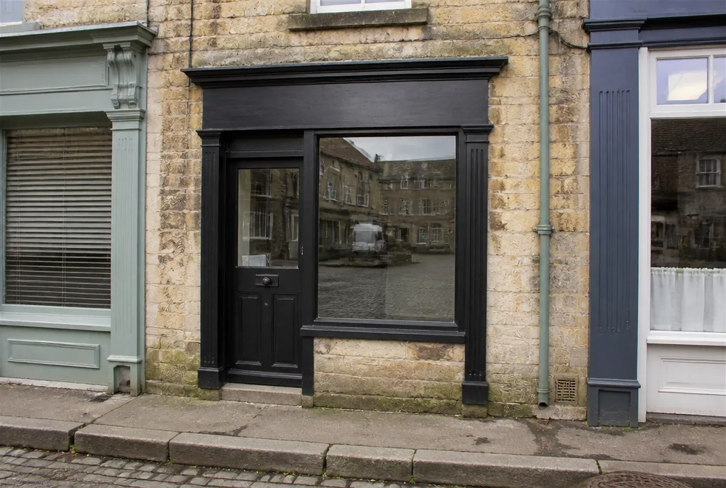 The Welland & Rook office on Market Place in Oakham, a small stone shopfront with a black-painted door