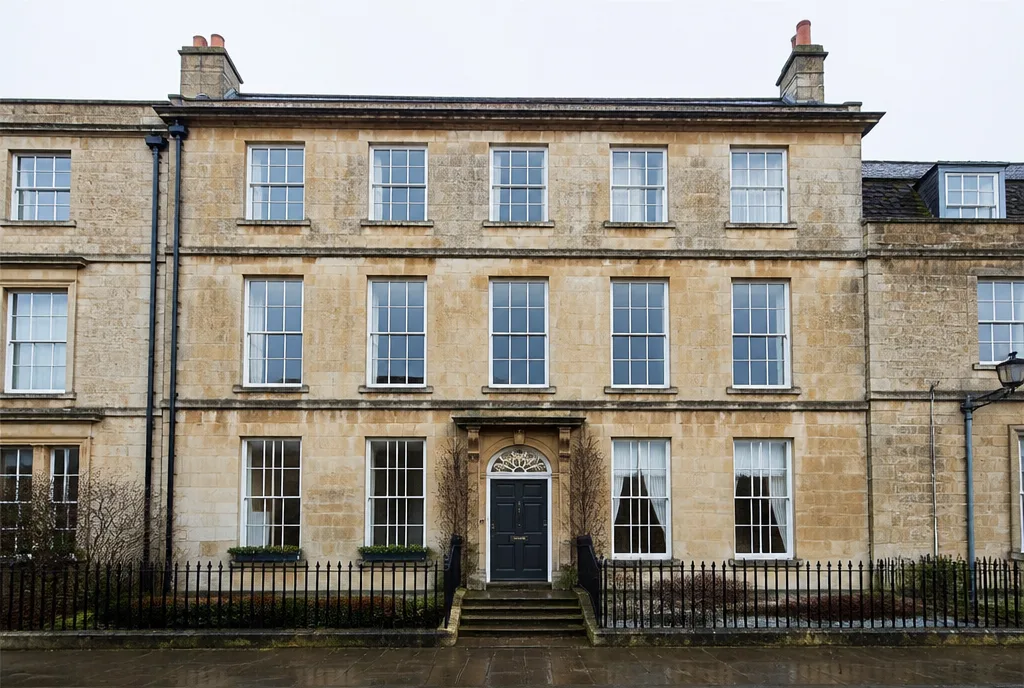 The five-bay limestone front of a Georgian townhouse on Barn Hill, Stamford, with railings and stone steps
