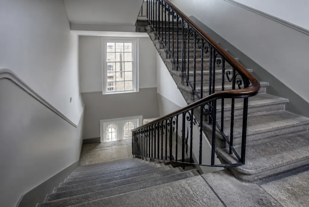 The communal stone stair and landing of the converted school building