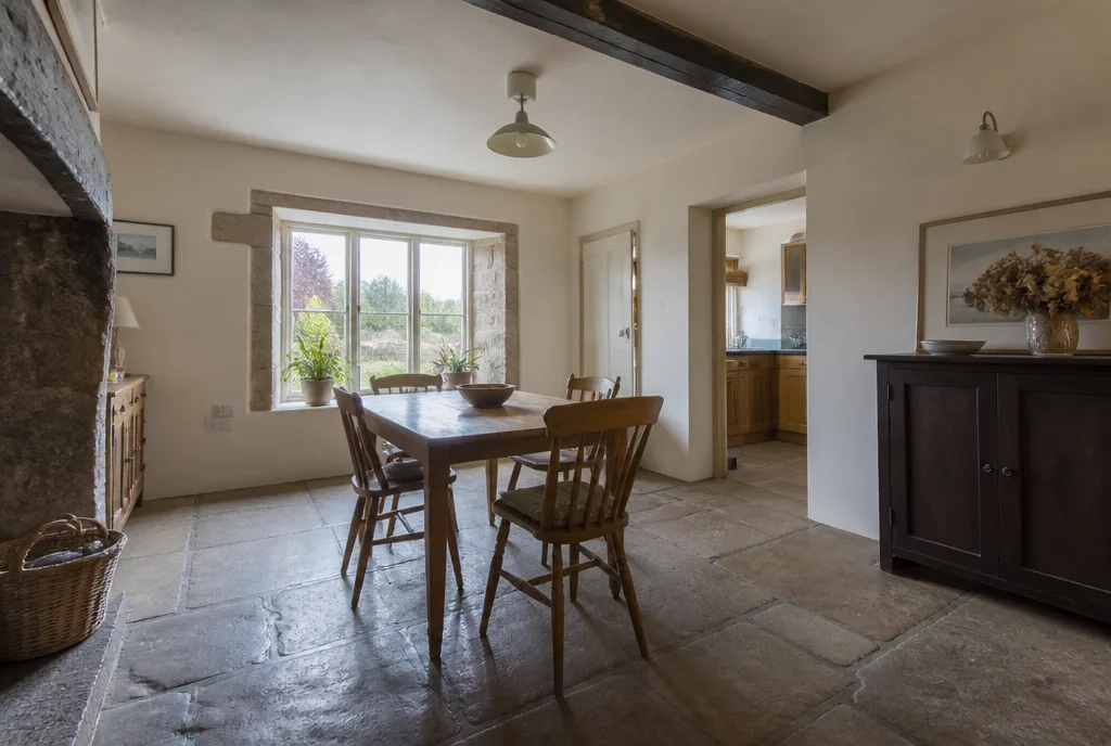 The dining room of the Uffington cottage with a flagstone floor and a window onto the garden