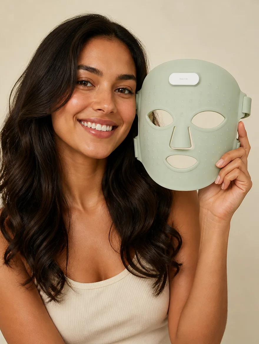 A smiling woman holding the Lumen Mask beside her face